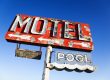 Old weathered retro neon motel sign advertising pool and vacancy. Horizontal shot.