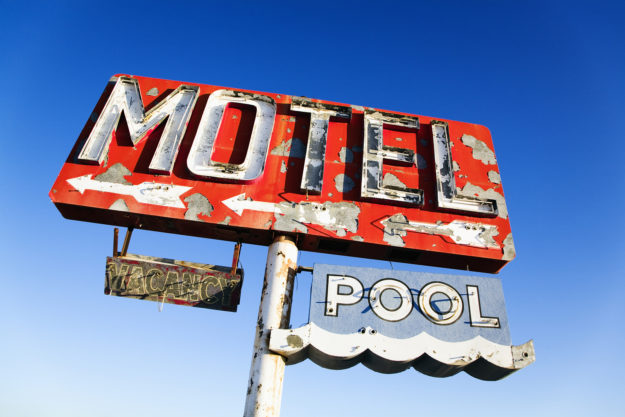 Weathered Retro Motel Sign Old weathered retro neon motel sign advertising pool and vacancy. Horizontal shot.