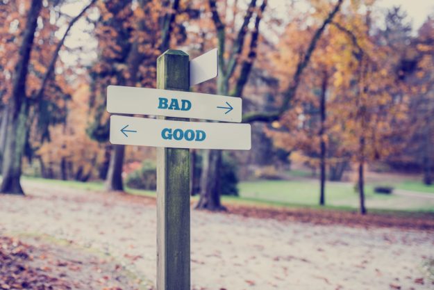 Rustic Wooden Sign In An Autumn Park With The Words Bad – Good Rustic wooden sign in an autumn park with the words Bad - Good offering a choice of action and attitude with arrows pointing in opposite directions in a conceptual image.