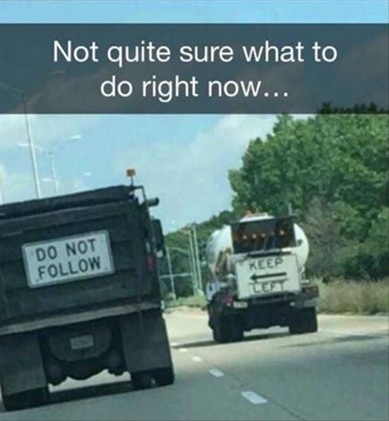 Two construction trucks with conflicting signage