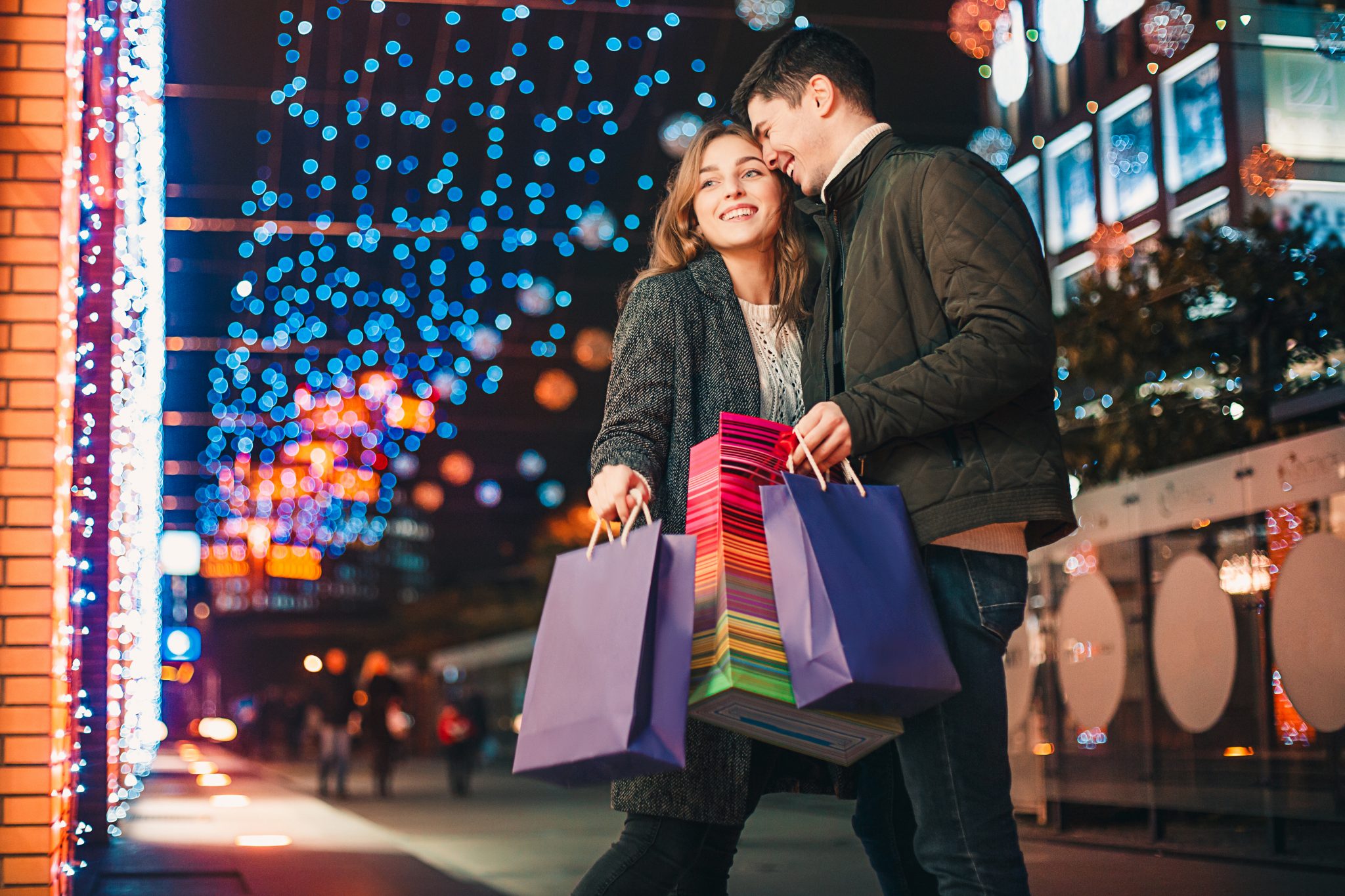 A couple does their holiday shopping and takes in lighted signs