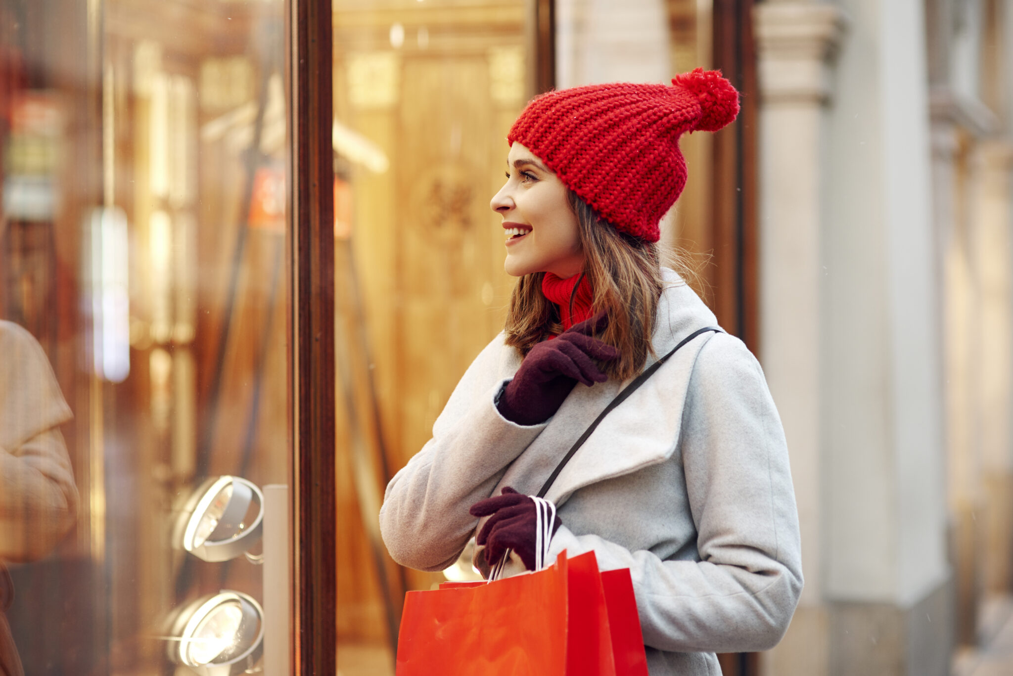 Beautiful woman looking on shop window during christmas shopping