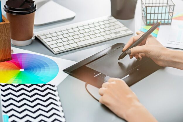 gray-desk-with-laptop-notepad-with-blank-sheet-pot-flower-stylus-tablet-retouching_155003-5220