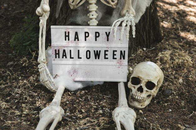 skeleton-leaning-tree-holding-halloween-tablet_23-2147905141