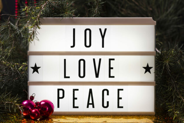 joy-love-peace-lettering Seasonal signage that communicates positive messages like this "Joy, love, and peace" sign can help your business to build brand loyalty. Photo by FreePik.