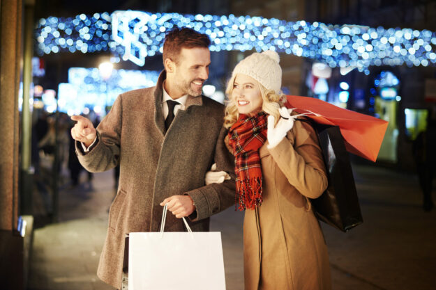 The shopping did not over yet A couple doing their holiday shopping, drawn into a store by strategic holiday signage